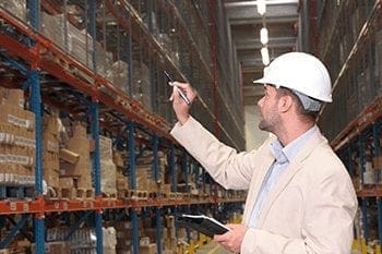 worker counting stocks in warehouse