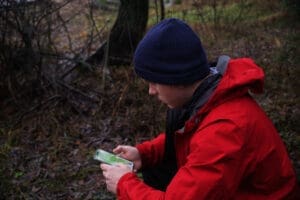 a man is looking at a navigation device on his phone. Hiking navigation, online maps